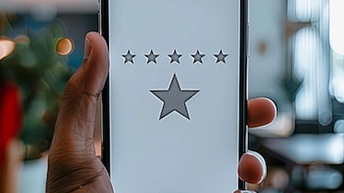 Hand holding smartphone with a star rating on the screen
