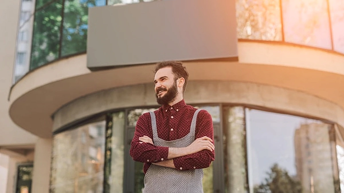 Confident bartender standing outside cafe