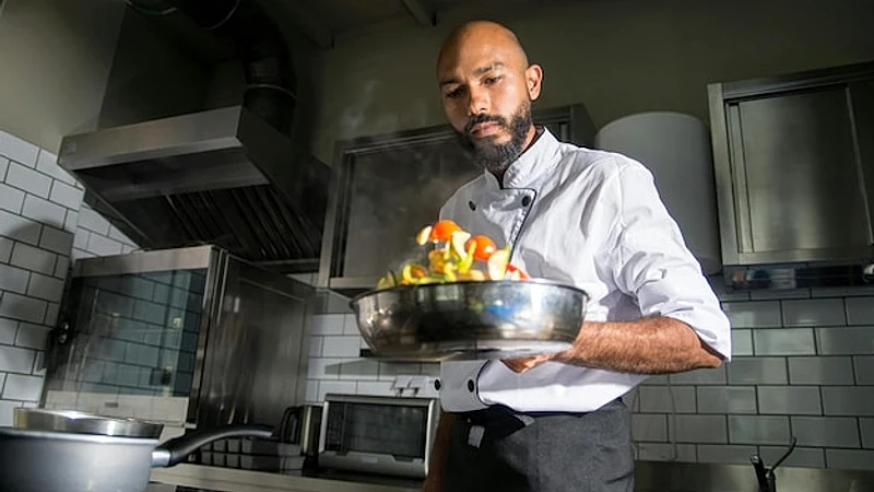 a man in a kitchen with a bowl of fruit and a bowl of fruit