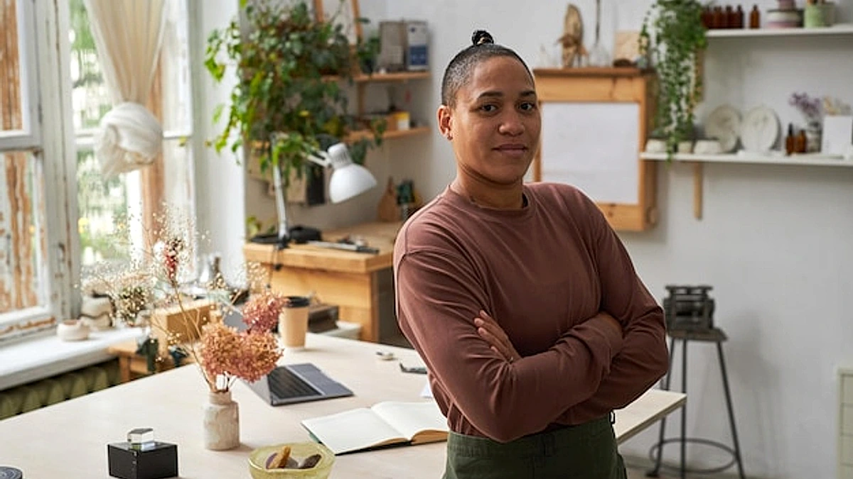 Confident female artist posing in workshop