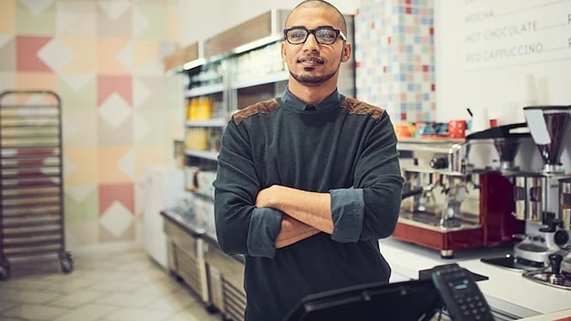 Portrait man and cafe with arms crossed at counter with confidence and satisfied in Mexico Male person entrepreneur and coffee shop as manager at small business as waiter or barista for service