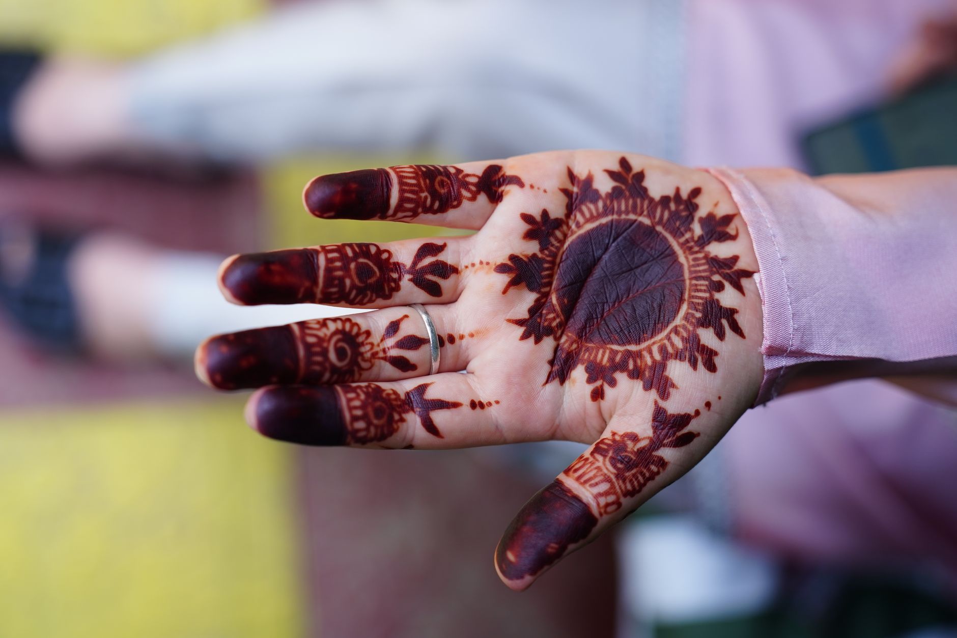 Close-up of a woman's hand featuring intricate henna art, showcasing traditional patterns.