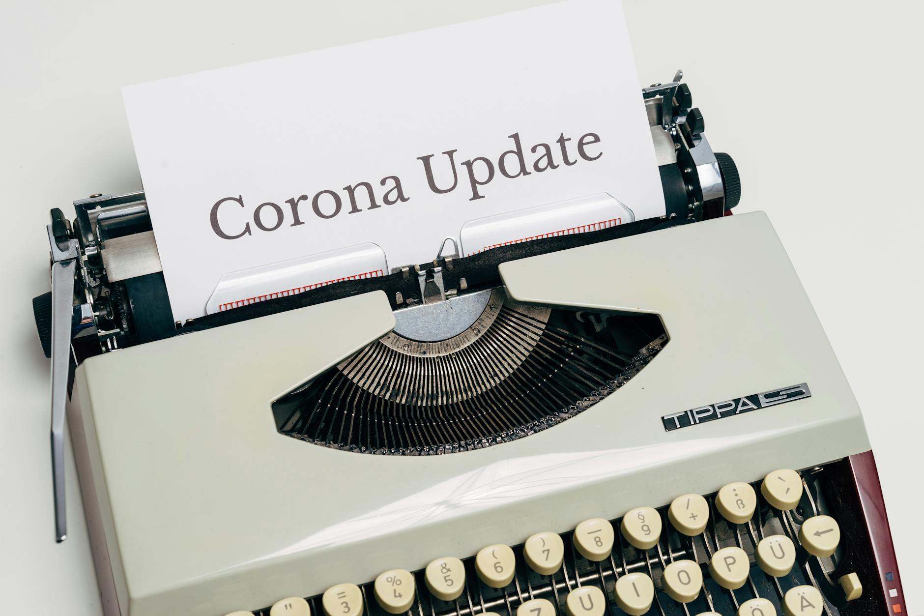 A vintage typewriter displaying a page with the words 'Corona Update' typed on it.