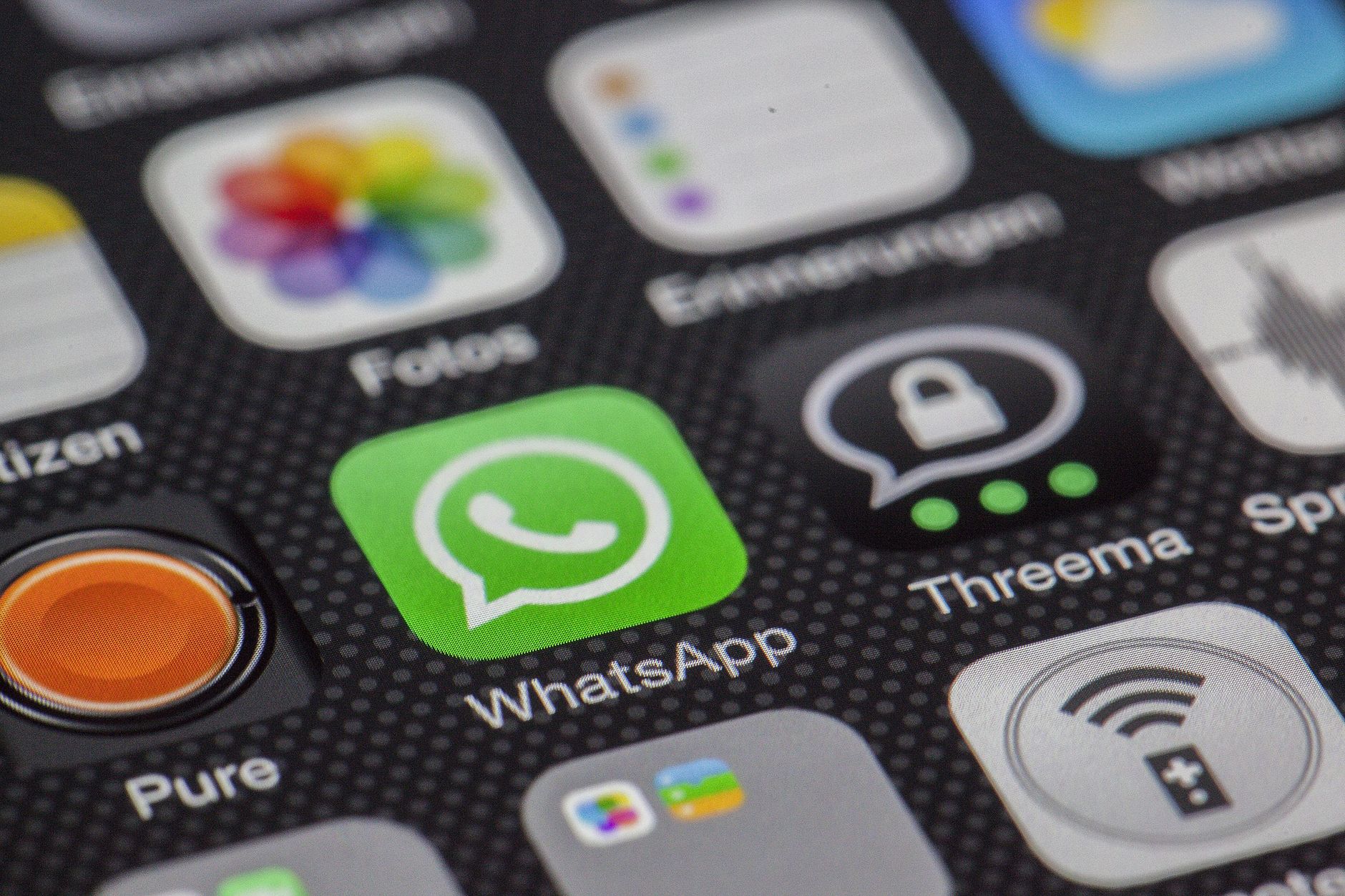 Detailed macro of smartphone screen showcasing popular app icons like WhatsApp.